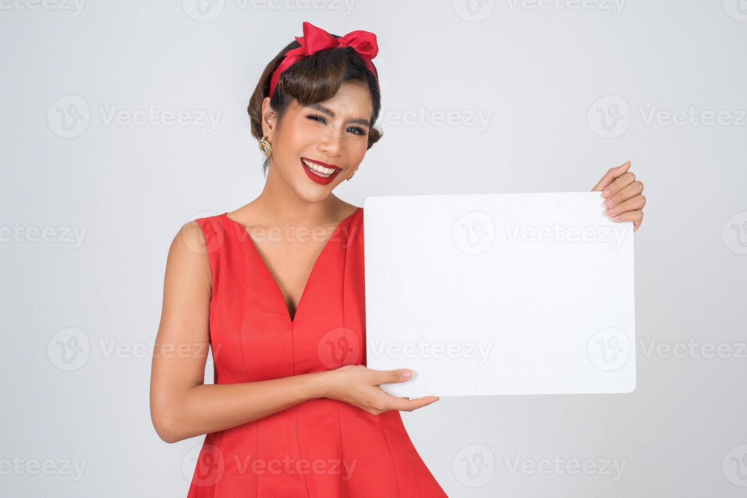 Retrato de una mujer de moda mostrando una pancarta blanca foto