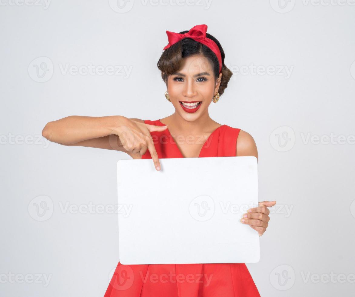 Retrato de una mujer de moda mostrando una pancarta blanca foto