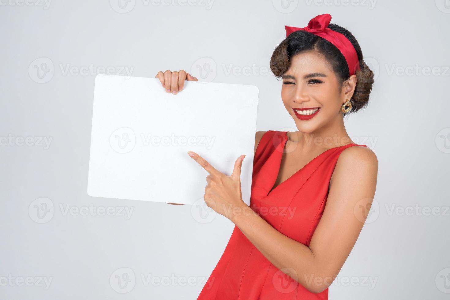 Retrato de una mujer de moda mostrando una pancarta blanca foto