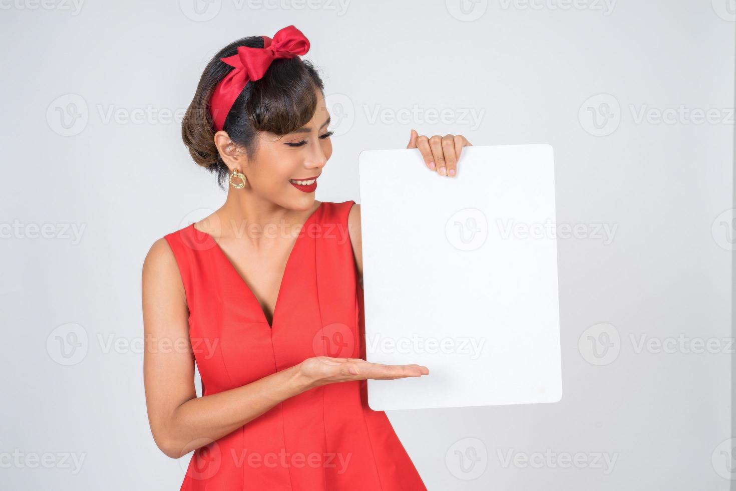 Retrato de una mujer de moda mostrando una pancarta blanca foto