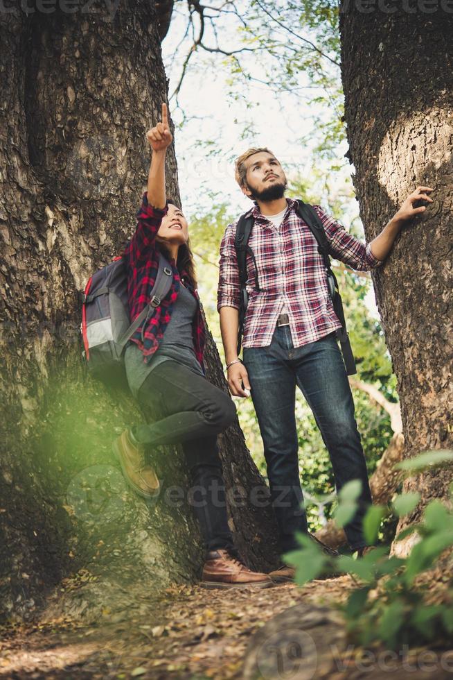 Hiker couple walking among trees photo