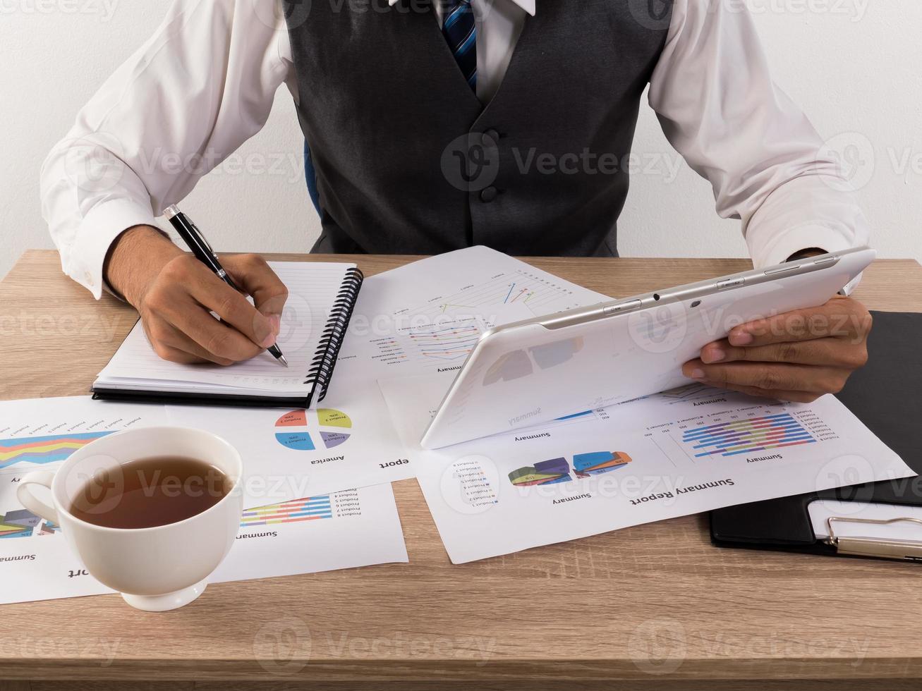 Hands of businessman working with data charts photo