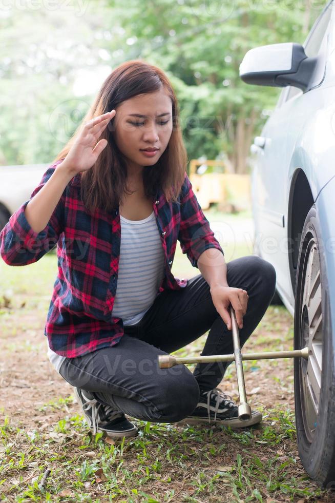 Young Hipster Woman Checking Out A Flat Tire On Her Car 2005139 Stock Photo At Vecteezy