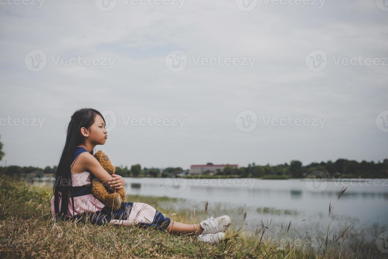 niña sentada con su oso molesto foto