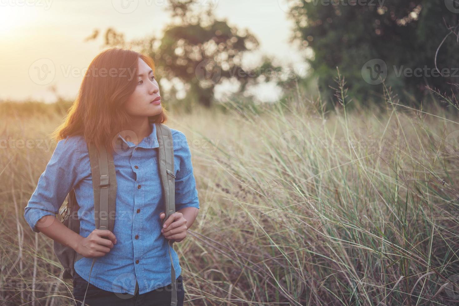 Imagen de tono vintage de una hermosa joven inconformista con mochila en un prado foto