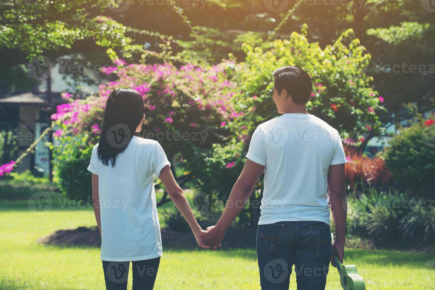 Young couple holding hands walking away together photo