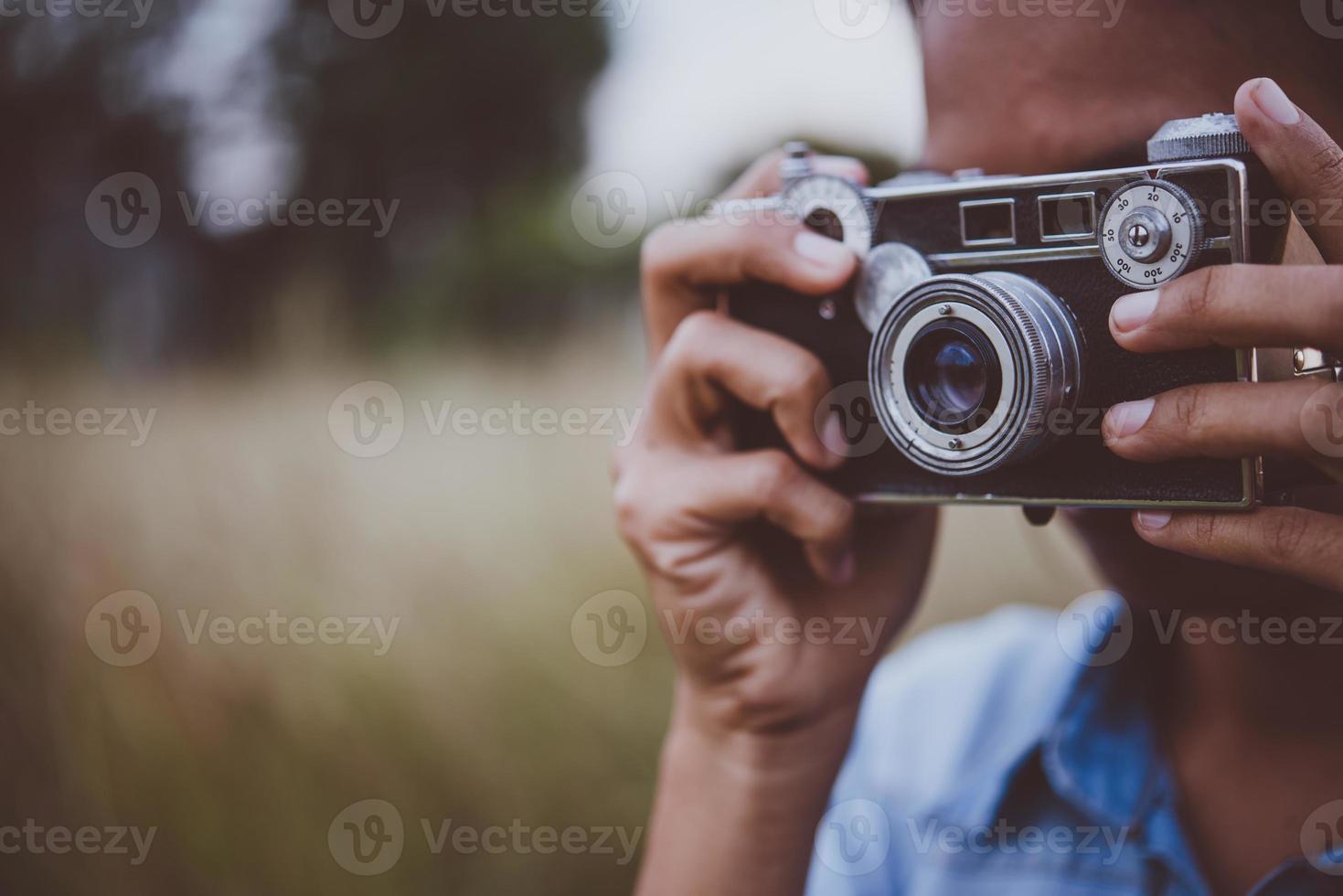 Young hipster woman takes a photo by a vintage camera