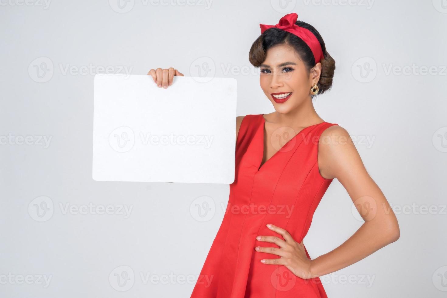 Retrato de una mujer de moda mostrando una pancarta blanca foto