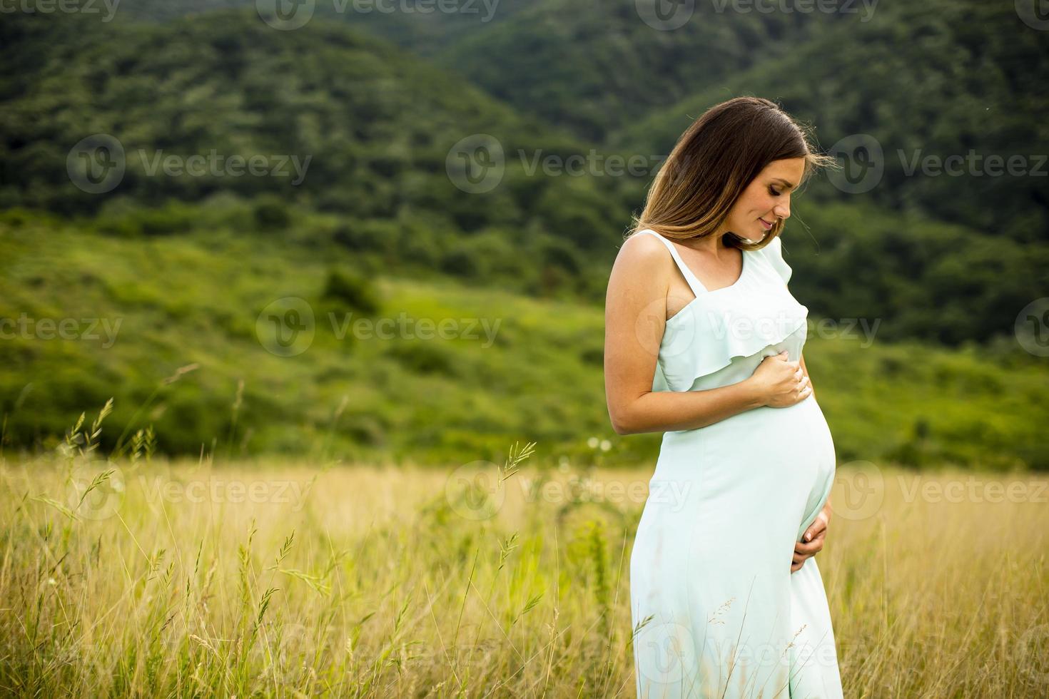 joven mujer embarazada relajarse afuera en la naturaleza foto