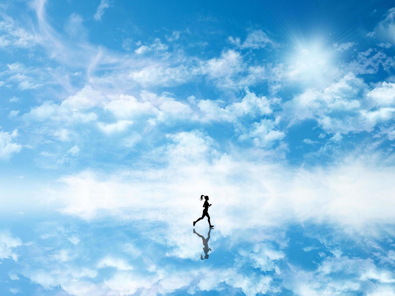 3D silhouette of a female jogging against a sky which is reflected in ground photo