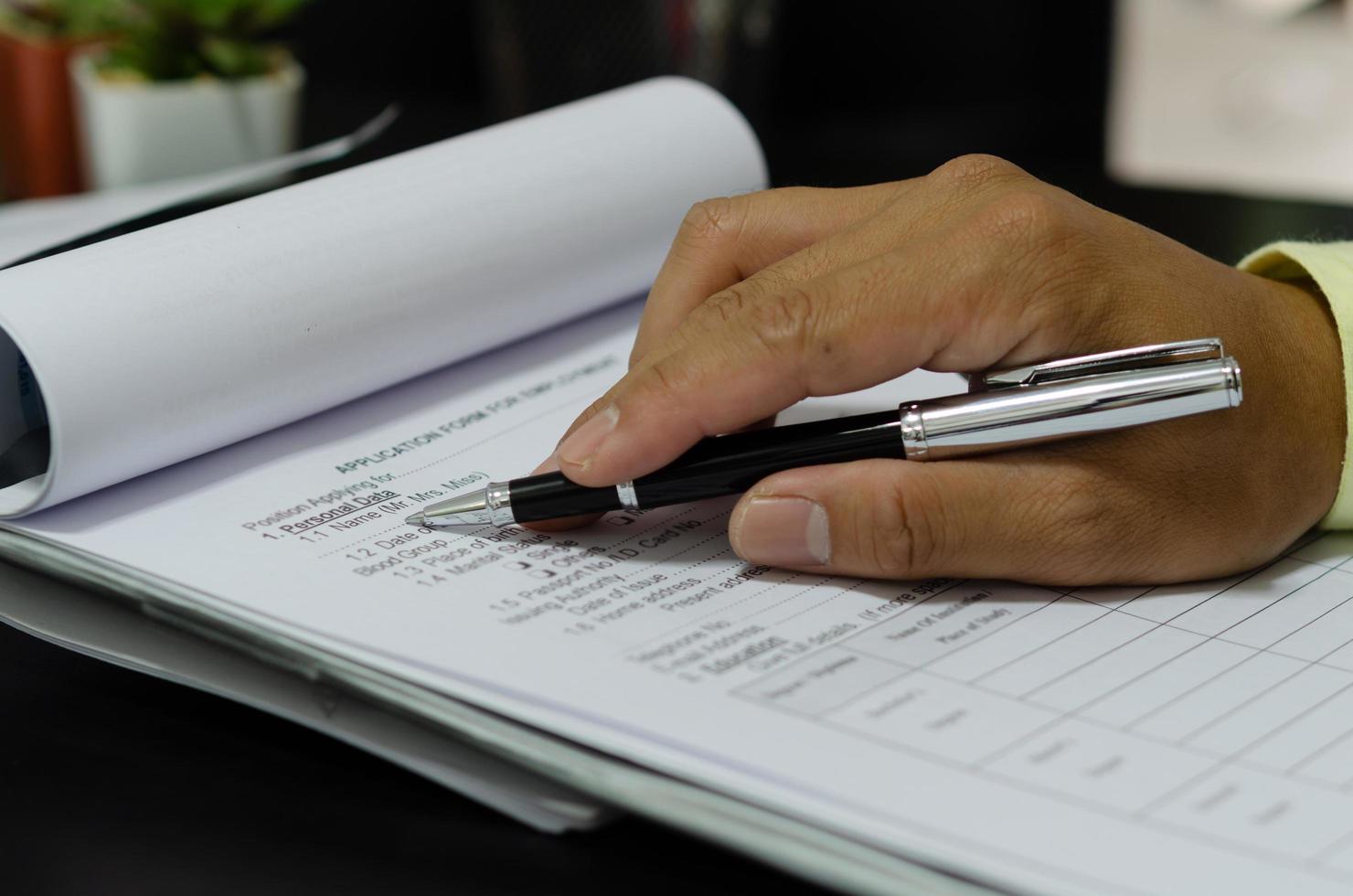 A businessman holding pen on business documents photo