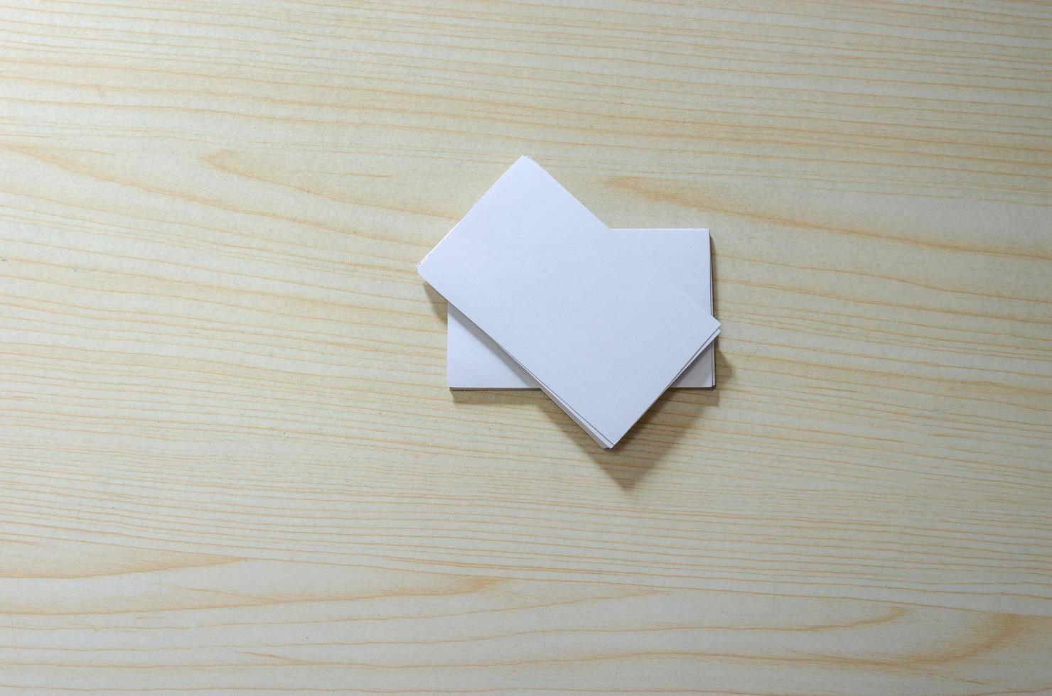 una maqueta de papel en blanco para tarjetas de visita en una mesa de madera foto