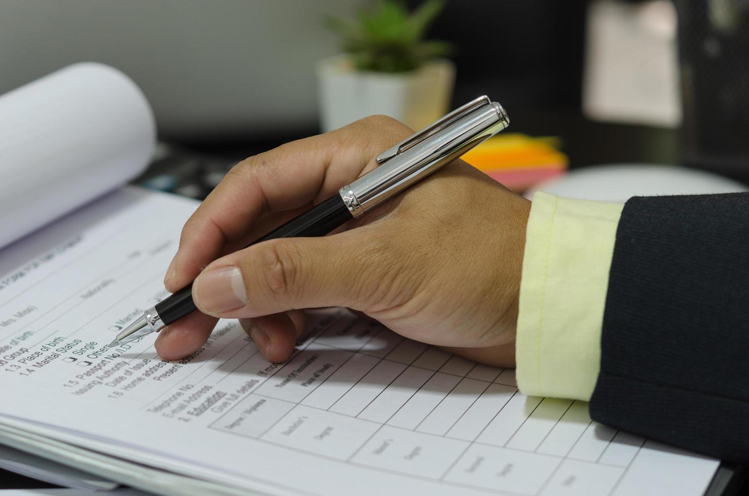 A businessman holding pen on business documents photo