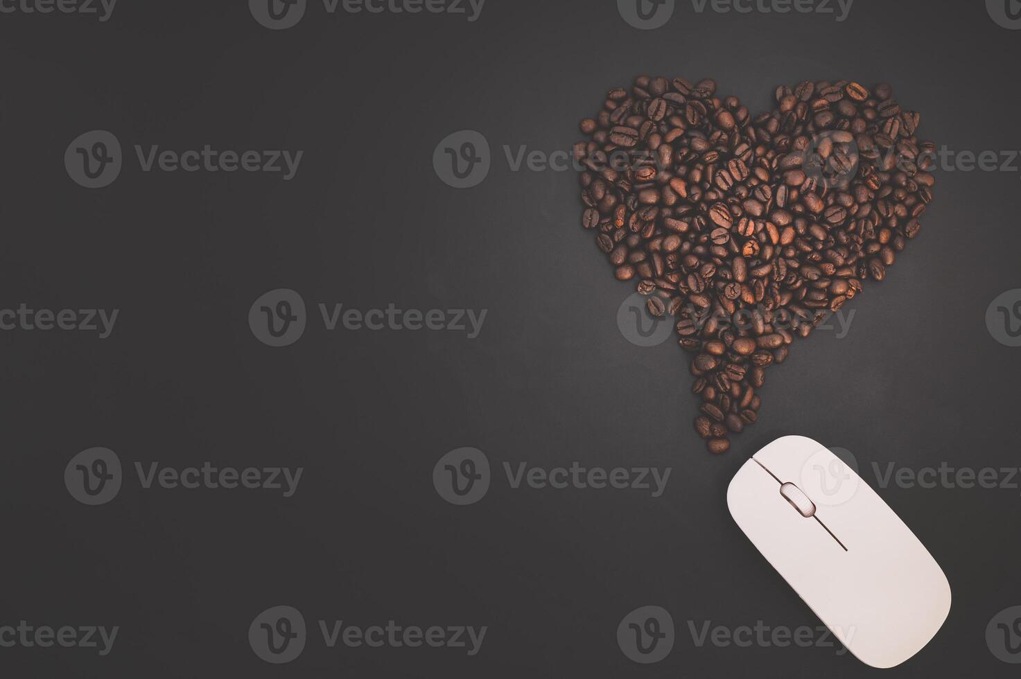 Coffee beans heart shape on a black background photo