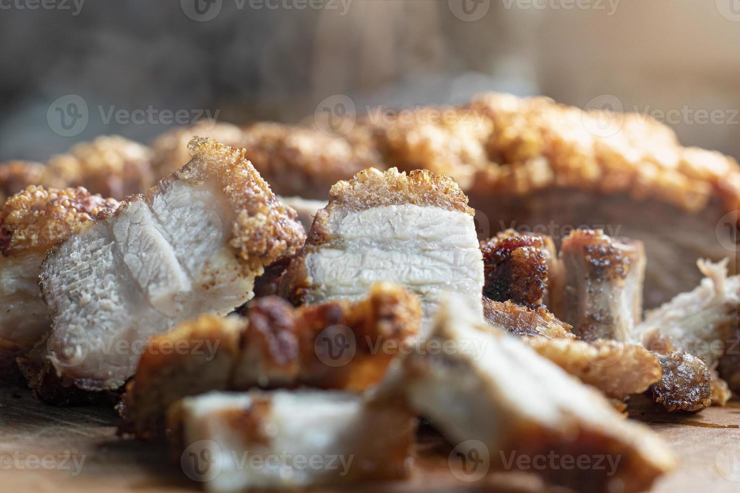 Close-up of fried pork belly slices on wooden table photo