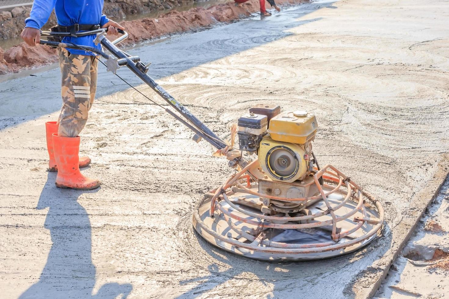 Trabajador de la construcción acabado de hormigón húmedo con una herramienta especial foto