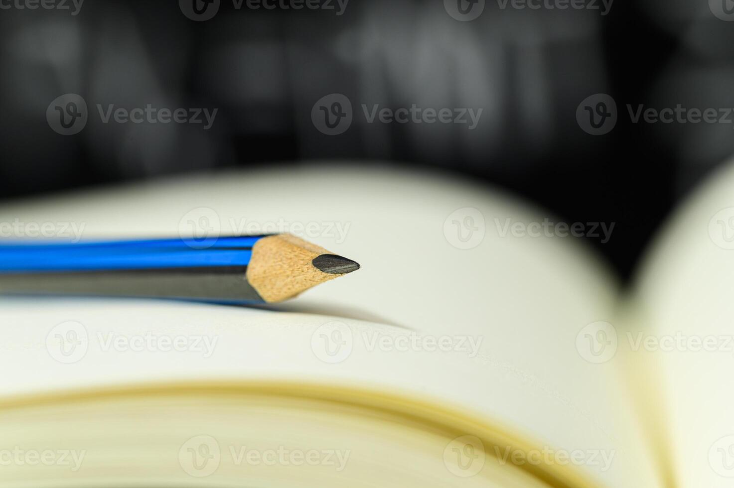 A pencil sitting on top of a book photo