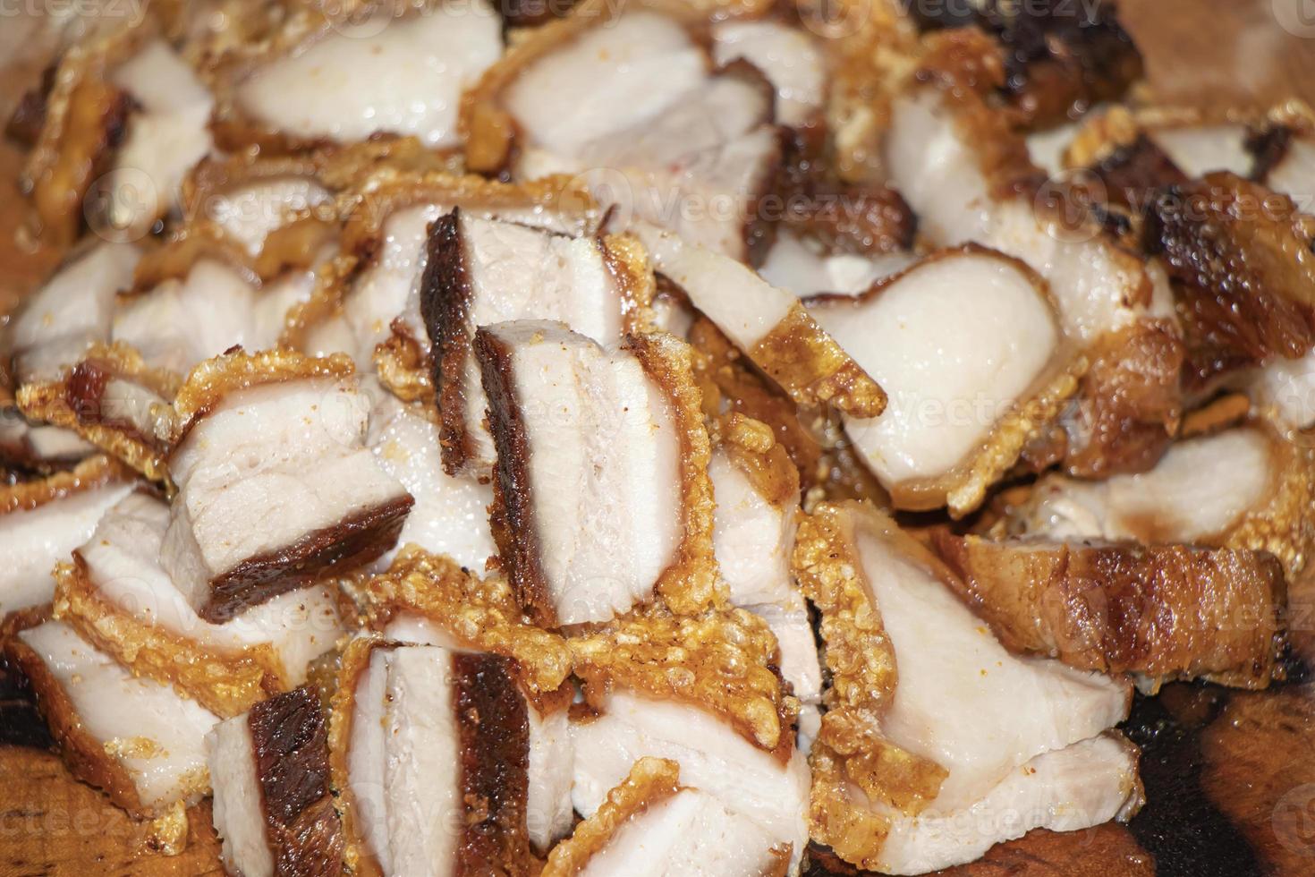 Close-up de lonjas de panceta de cerdo frito sobre mesa de madera foto