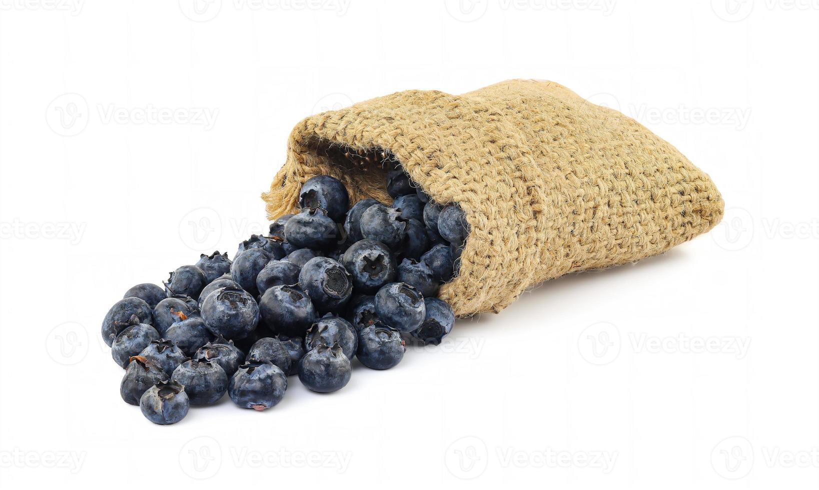 Blueberries in burlap sack on white background photo