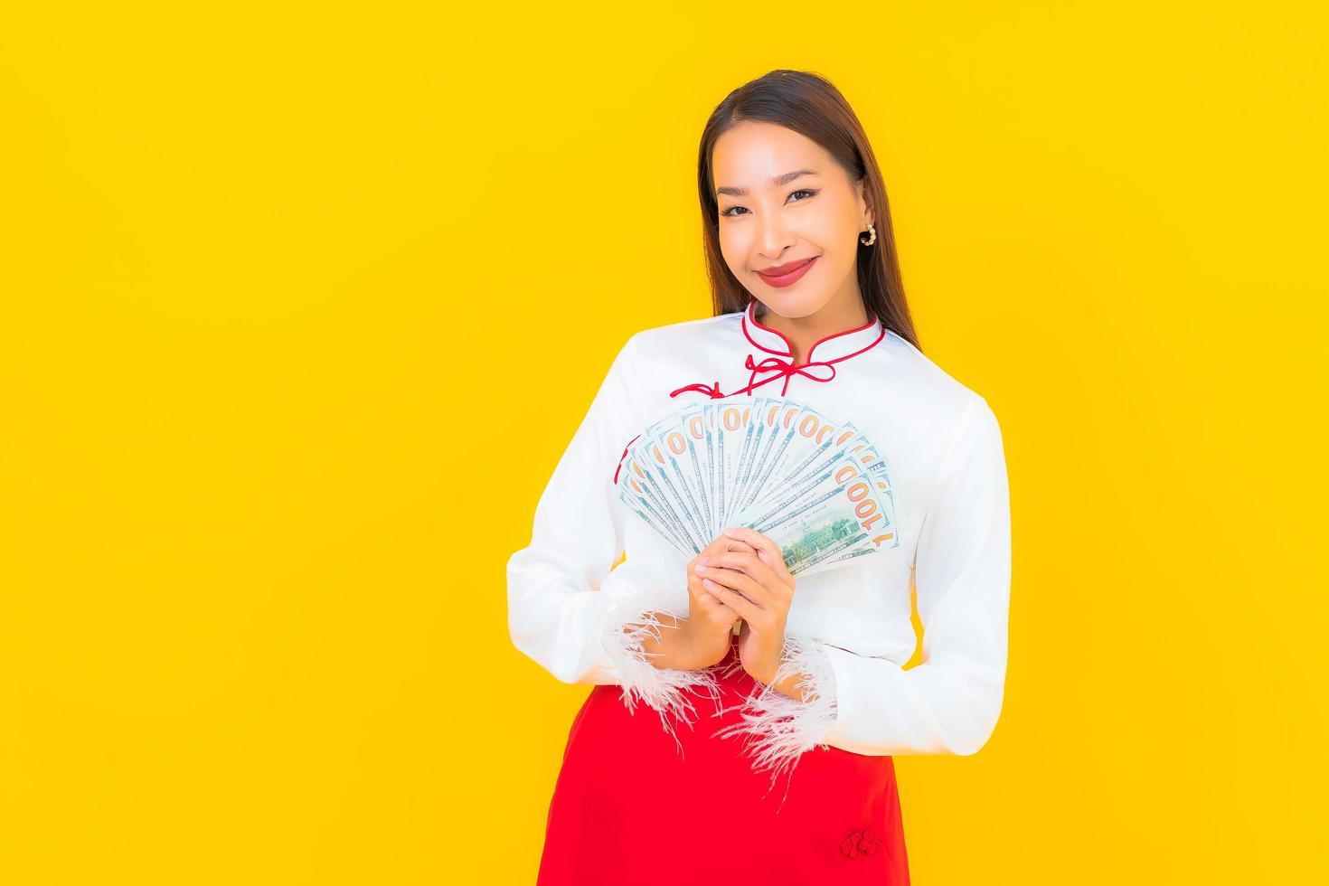 hermosa joven asiática sentada con mucho dinero en efectivo foto
