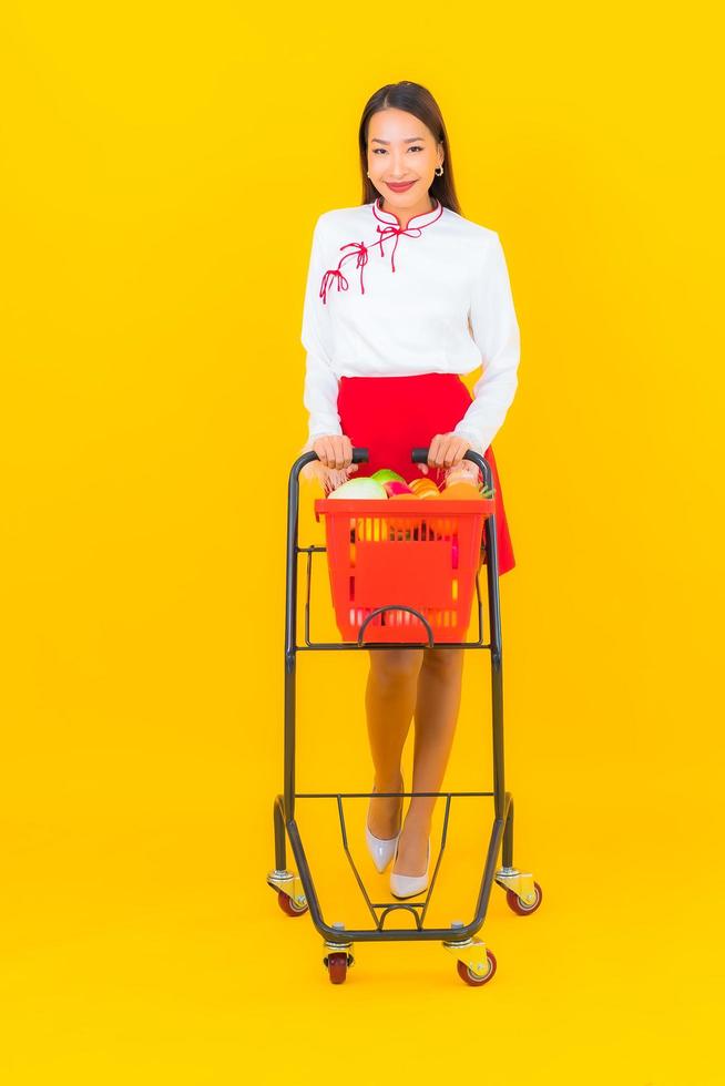 Beautiful young Asian woman with shopping cart photo