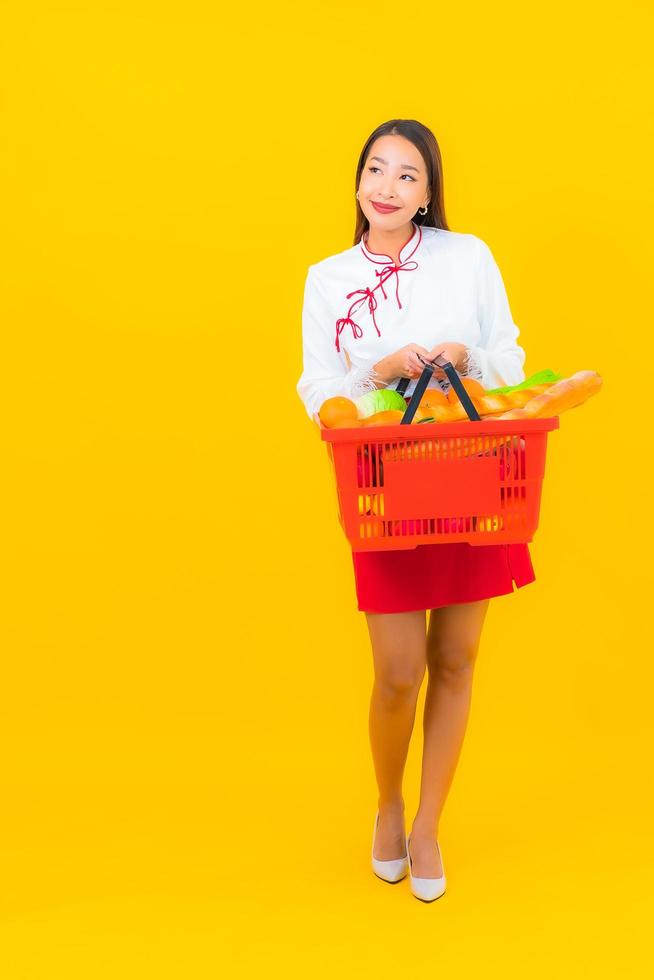 Beautiful young Asian woman with shopping basket photo