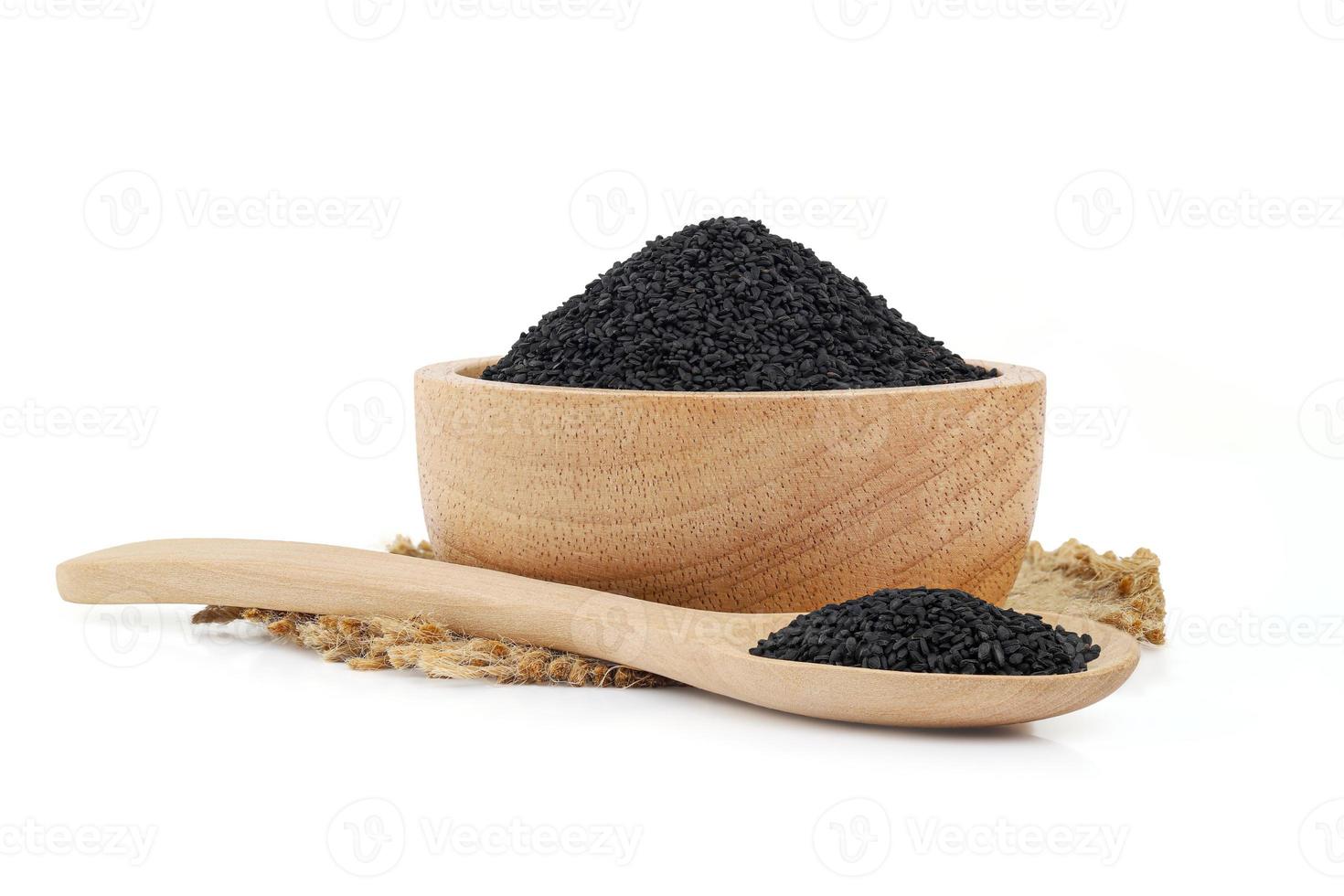 Black sesame in wooden bowl and spoon on burlap on white background photo
