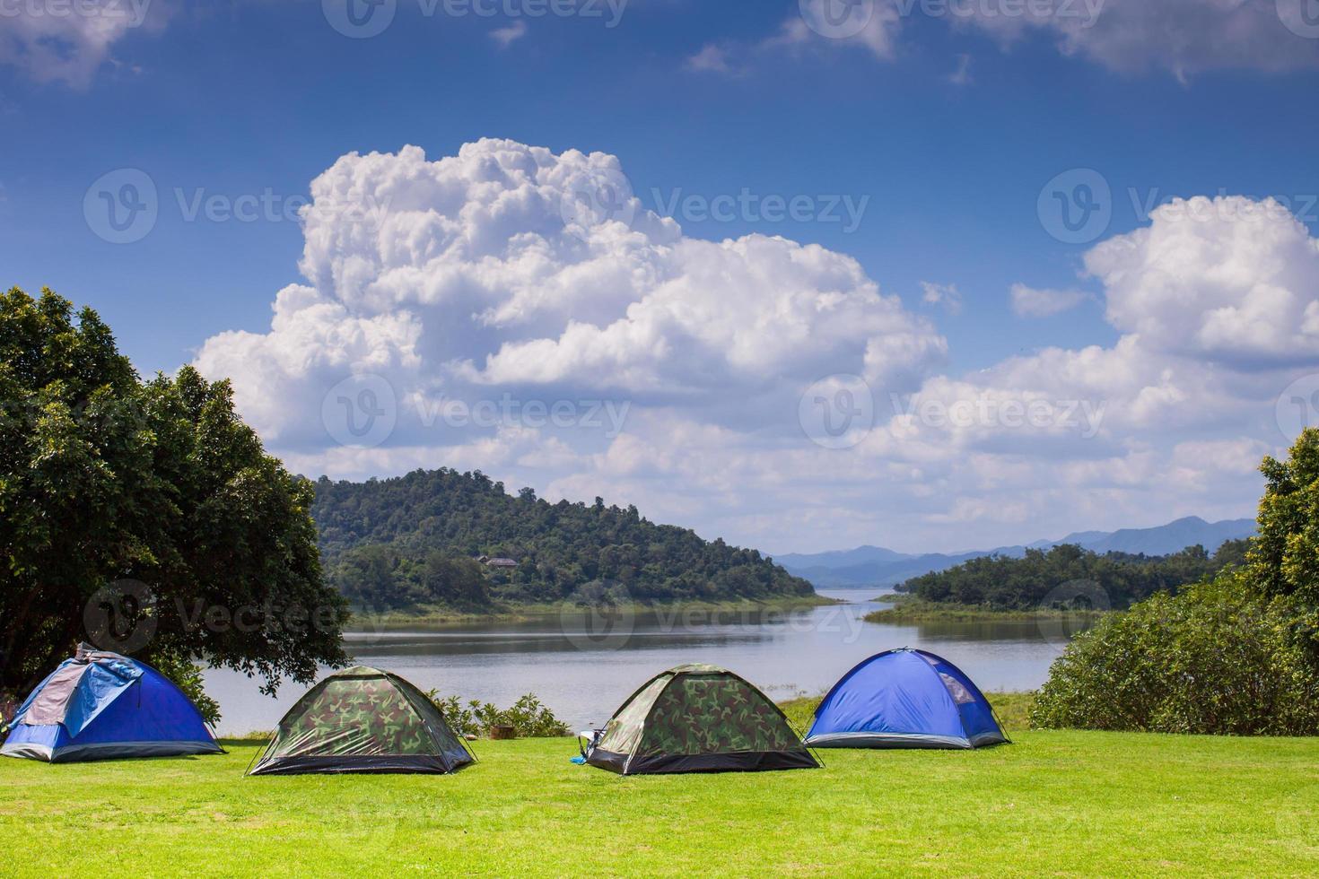 Tents near water and mountains photo