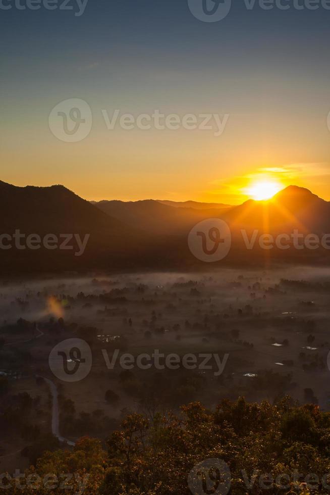 Sun rising over foggy mountains photo