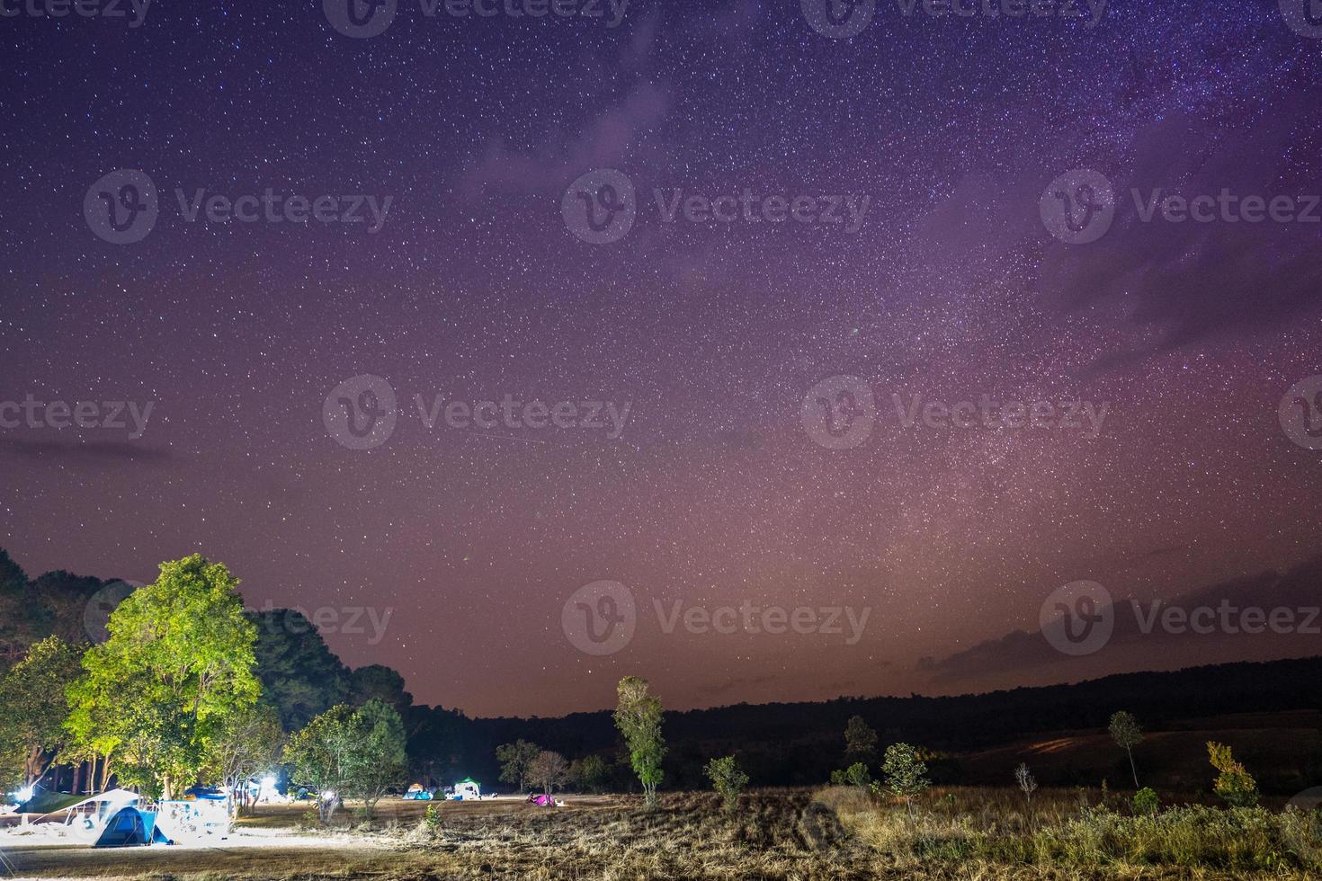 Colorful starry sky above a campsite photo