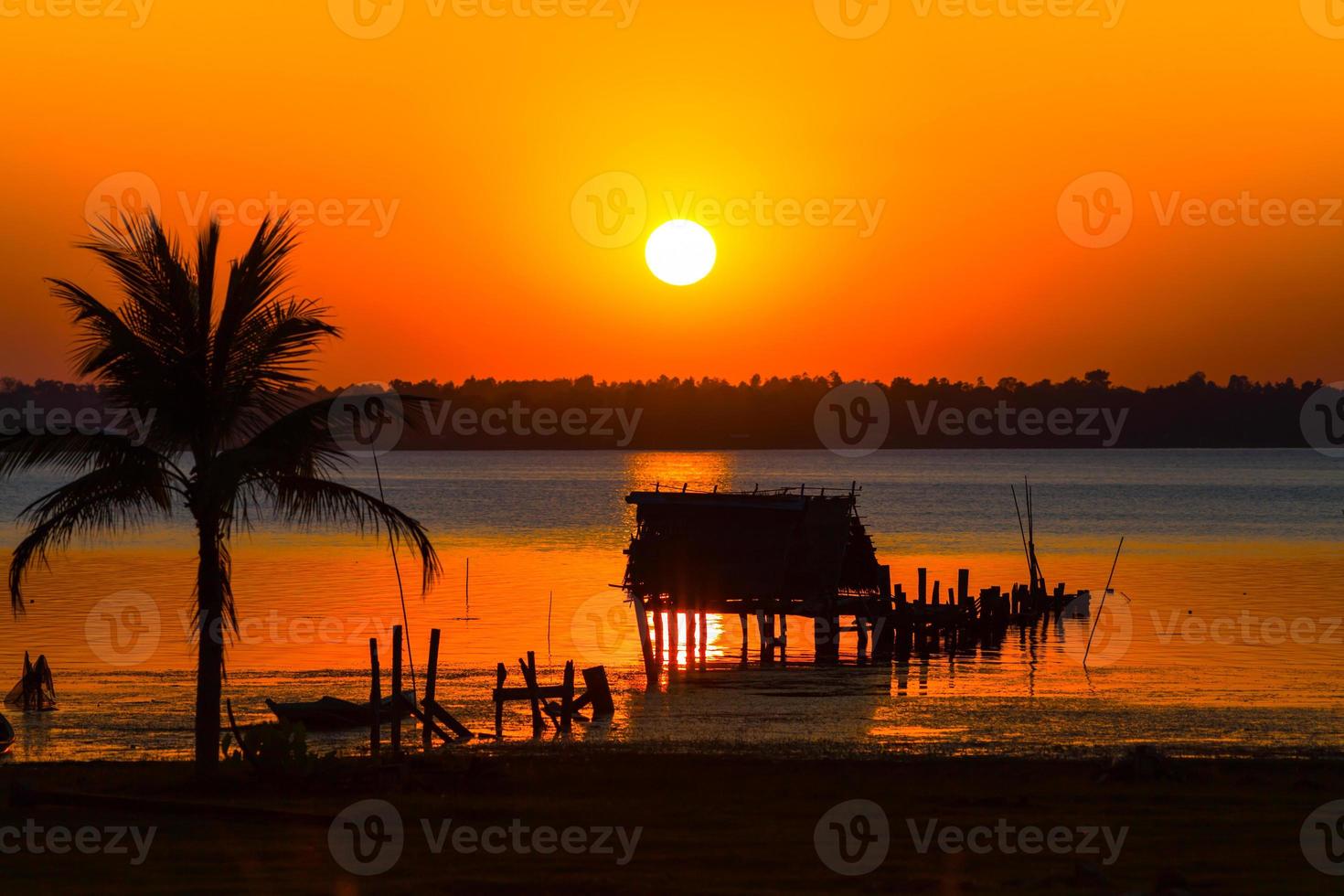 Silhouette of a hut against a colorful sunset photo