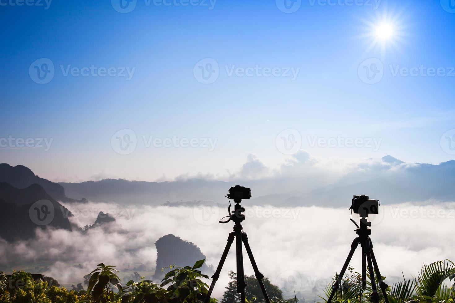 Cameras on tripods above fog photo