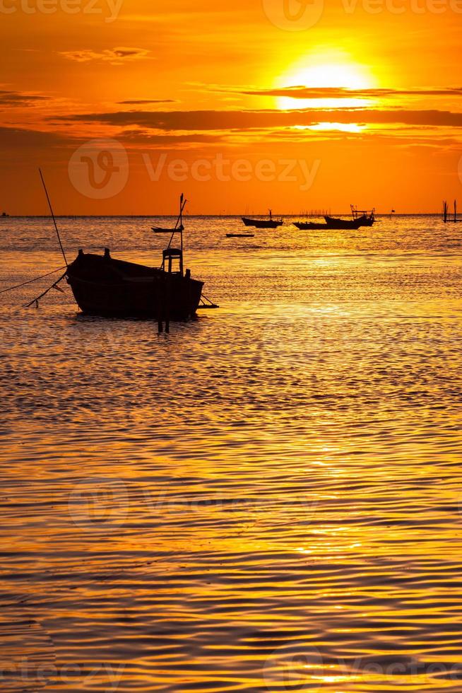 siluetas de barcos al atardecer foto