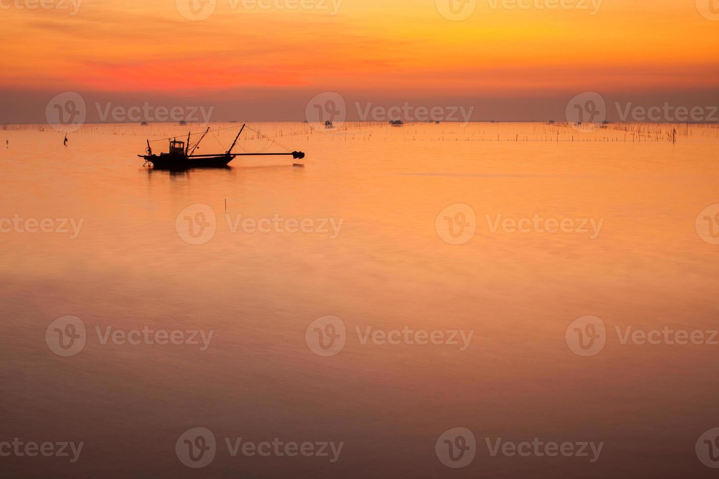 Silhouette of a fishing boat at sunset photo