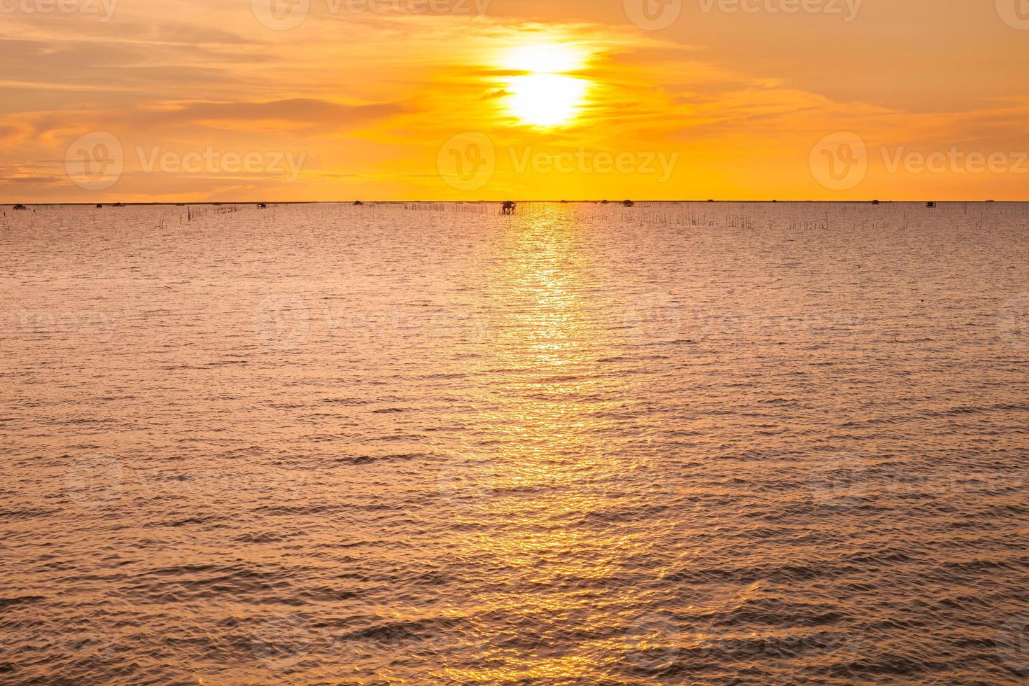 una puesta de sol naranja sobre un cuerpo de agua foto