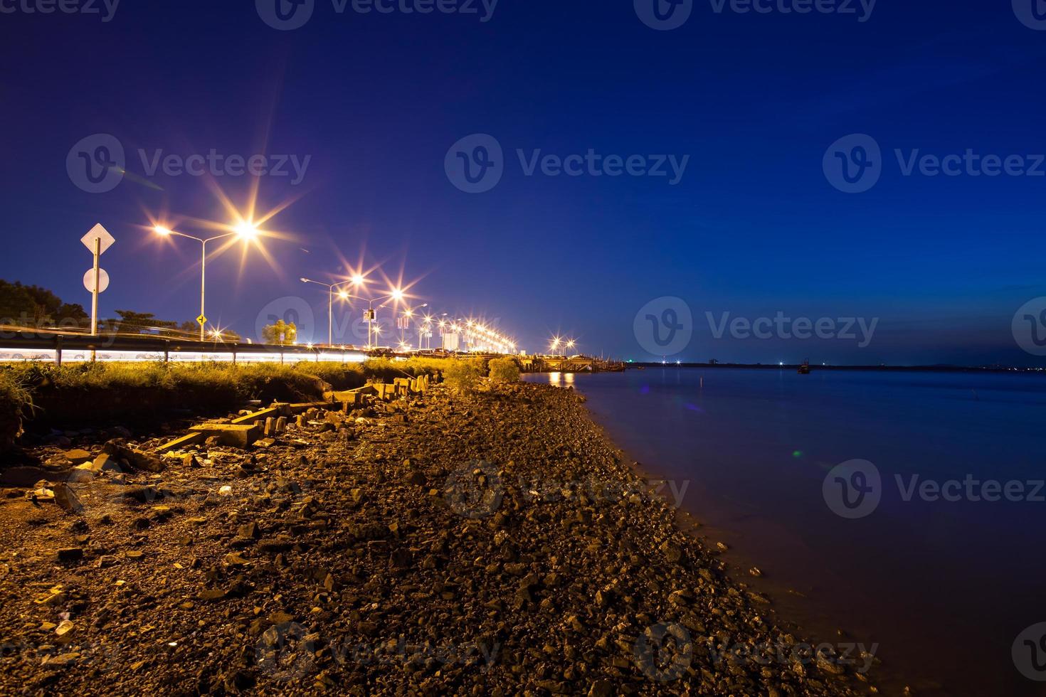 Road near water at night photo