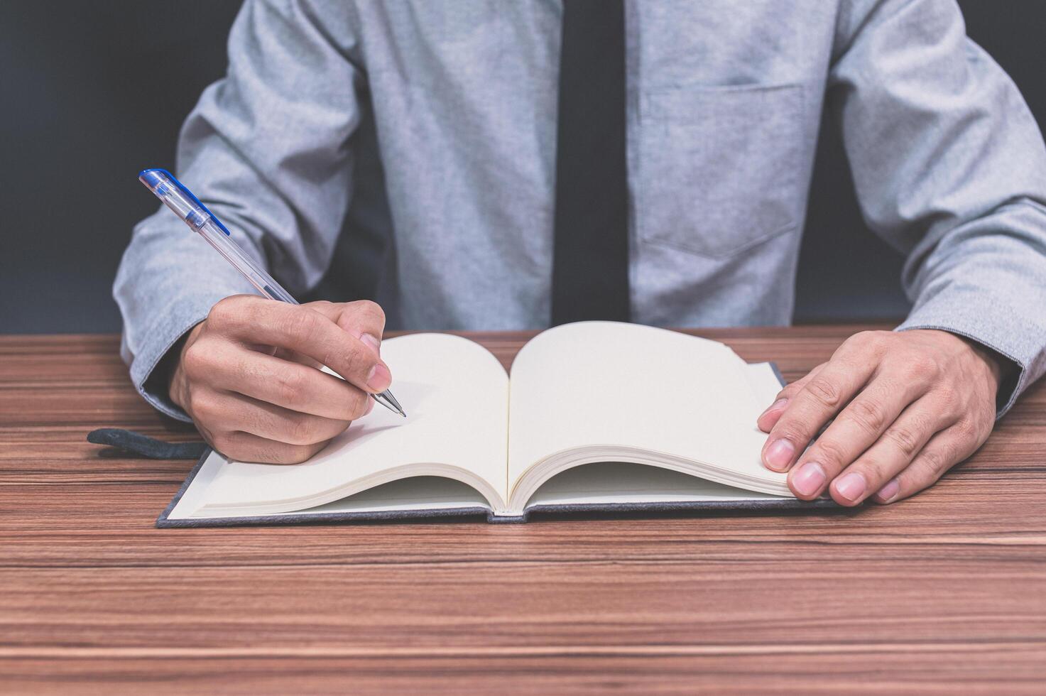 un hombre escribiendo en su escritorio foto