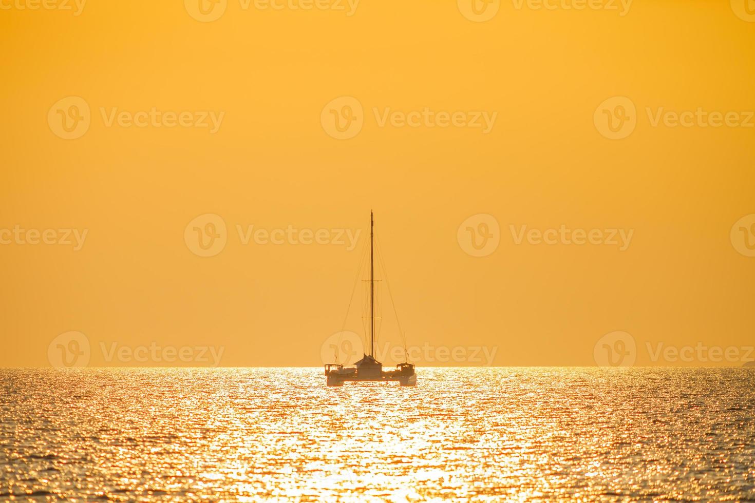 barco en el agua con una puesta de sol naranja foto