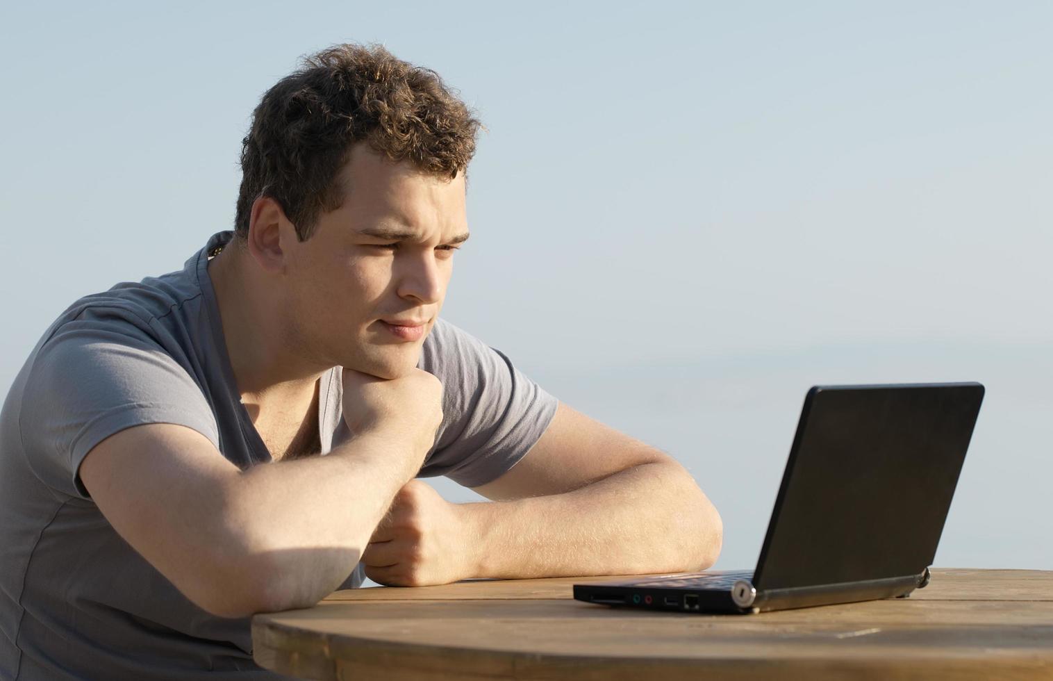 Man using a laptop outside photo