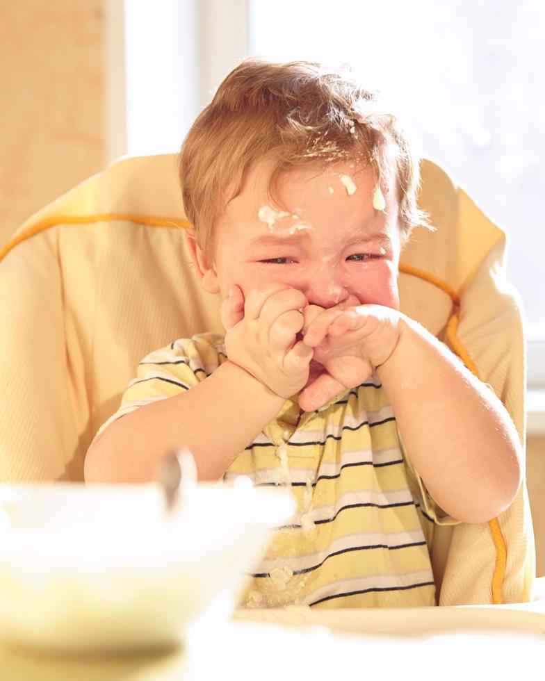 niño triste comiendo foto