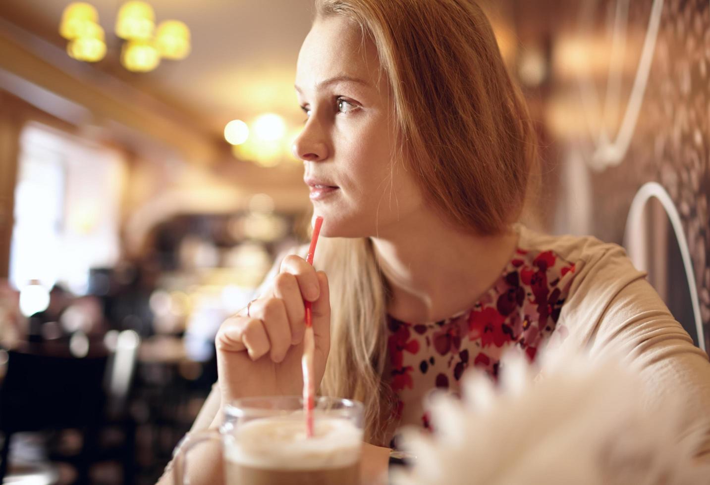 Woman holding a straw and looking away photo