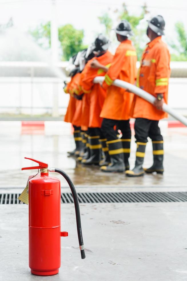 Bomberos rociando agua a alta presión de la manguera foto