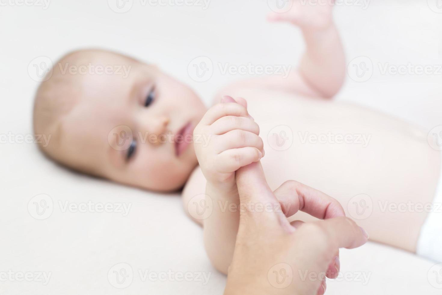 niña sosteniendo el dedo de la madre foto