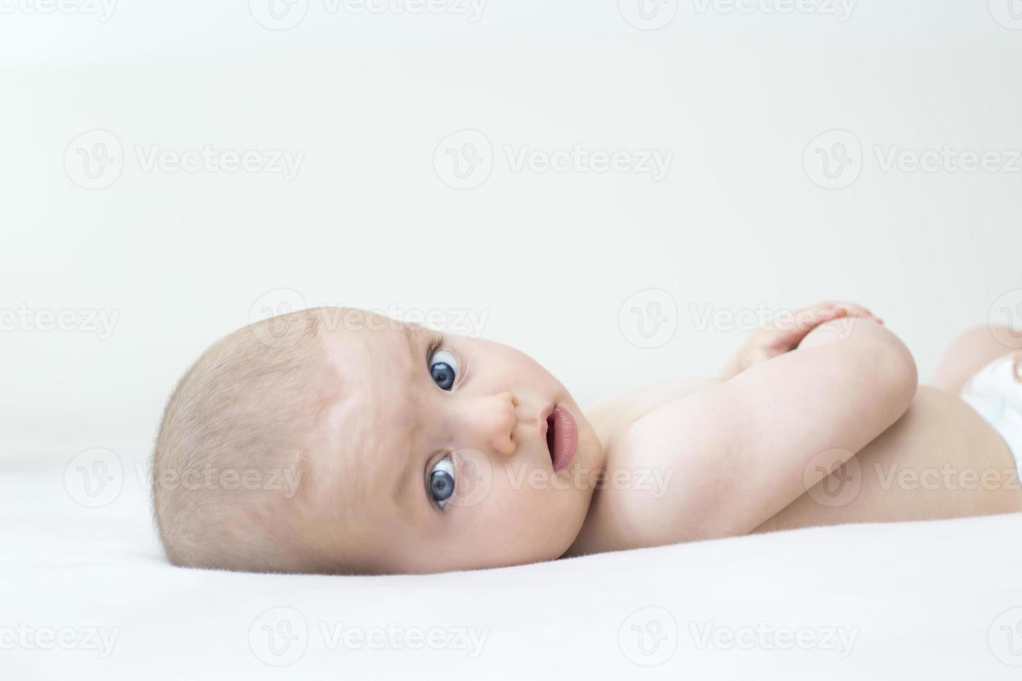 Cute baby girl lying on bed photo