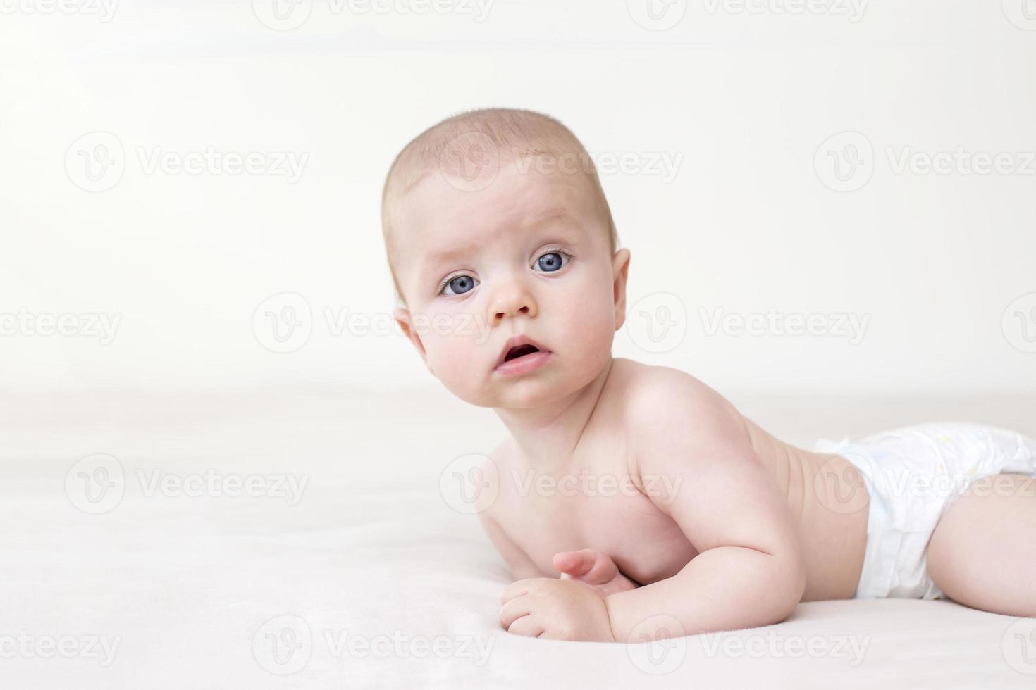 Cute baby girl lying on bed photo