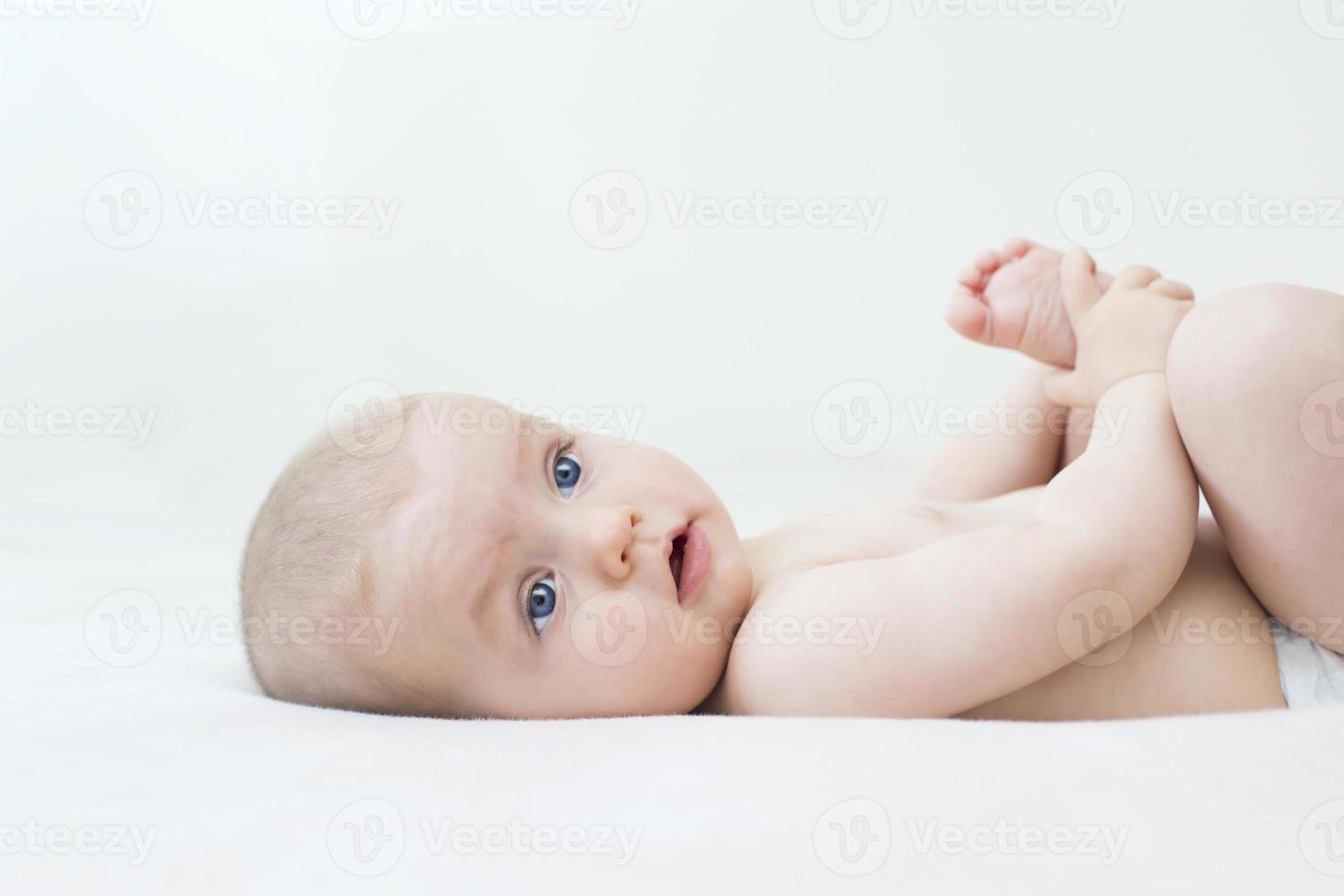 Cute baby girl lying on bed photo