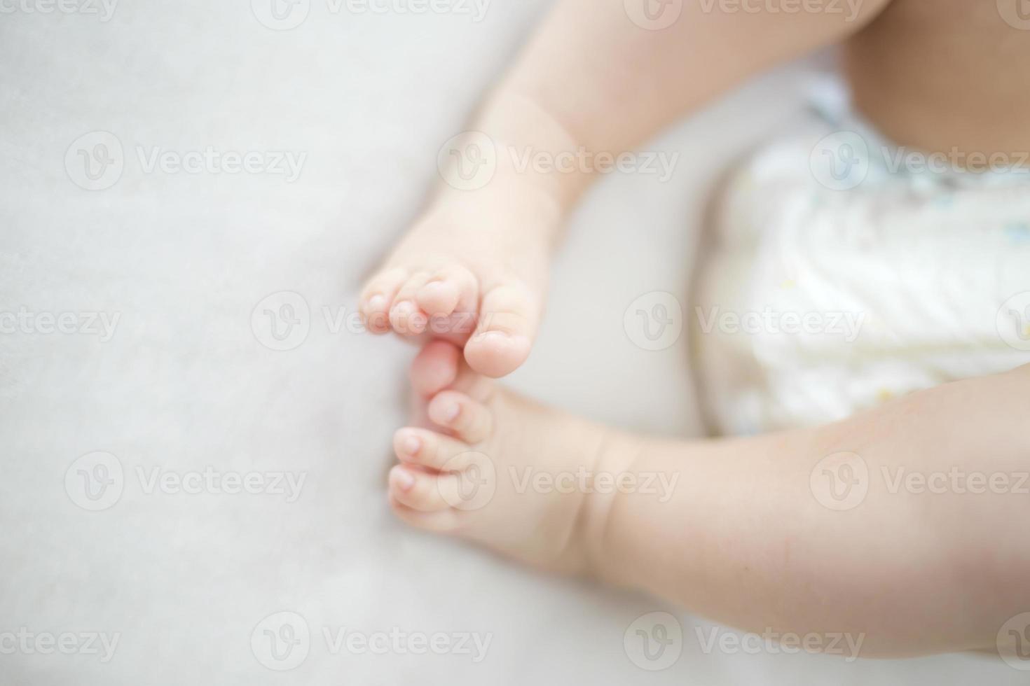 pequeños pies de niña en la cama foto