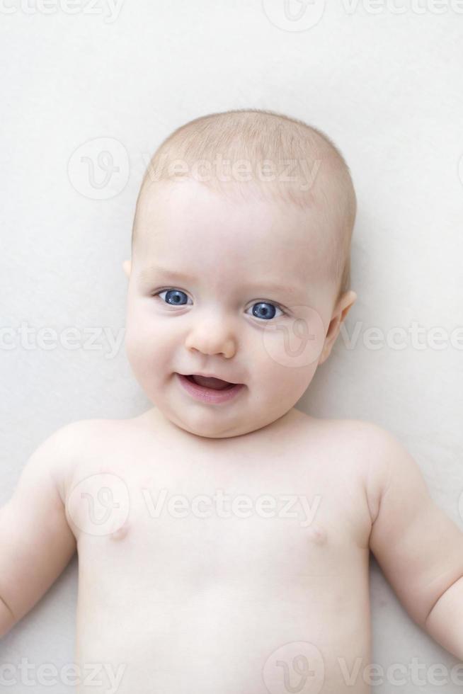 Cute baby girl lying on bed photo