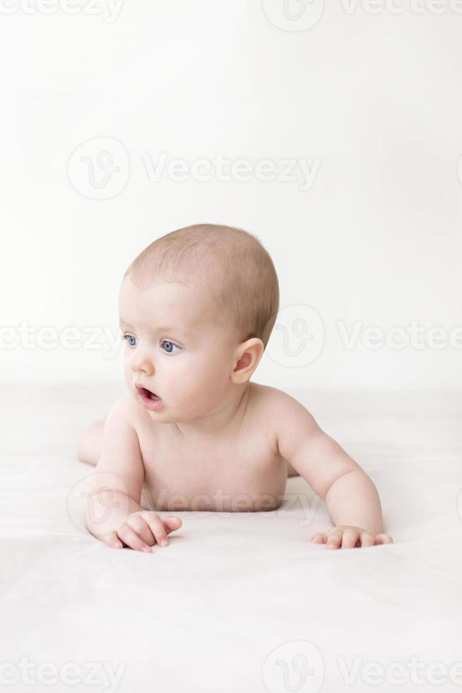 Cute baby girl lying on bed photo