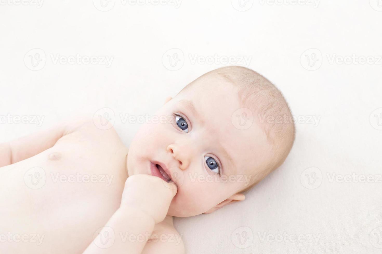 Cute baby girl lying on bed photo